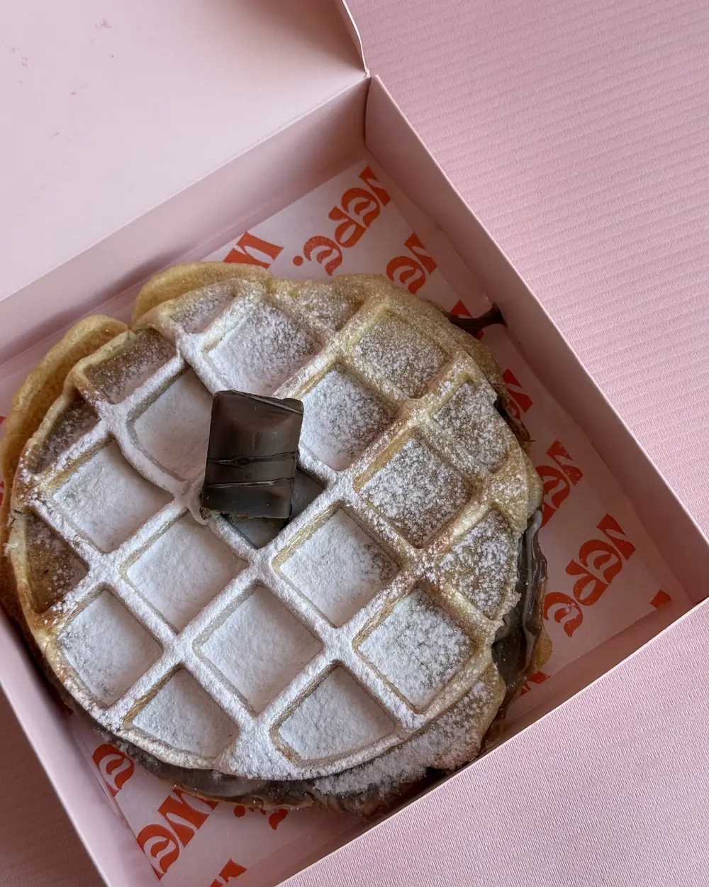 WEPE chocolate-filled waffle dusted with icing sugar in a pink WEPE box, Pererenan, Bali
